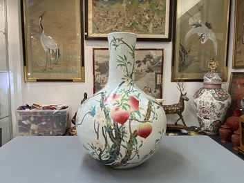 Un vase de forme 'tianqiu ping' en porcelaine de Chine famille rose &agrave; d&eacute;cor de neuf p&ecirc;ches, marque de Qianlong, 20&egrave;me