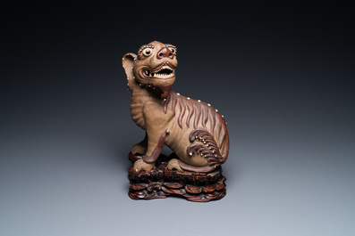 A Chinese Yixing stoneware dog on wooden stand, 19th C