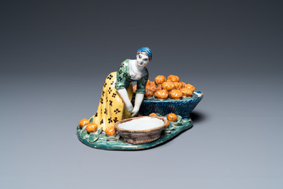 A polychrome Dutch Delft figure of a fruit seller with a small tureen, 18th C.