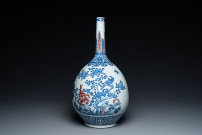 A Chinese blue, white and copper-red bottle vase with a deer and birds among blossoming branches, Daoguang