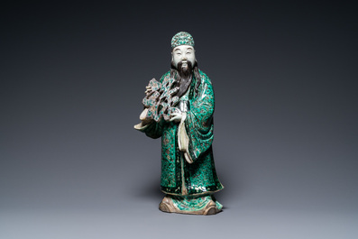 A Chinese verte biscuit figure of an immortal, 19th C.