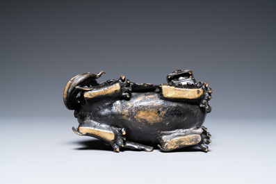 A rare Chinese bronze mythical animal 'Kaiming Shou' holding a lotus base, Ming