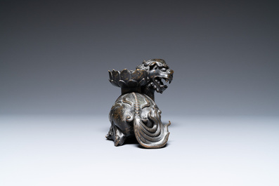 A rare Chinese bronze mythical animal 'Kaiming Shou' holding a lotus base, Ming