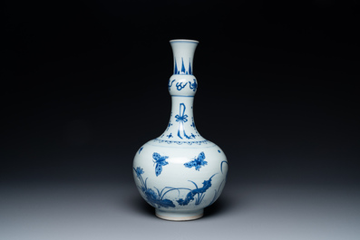 Un vase de forme bouteille en porcelaine de Chine en bleu et blanc figurant un l&eacute;zard, une grenouille et deux papillons, &eacute;poque Transition