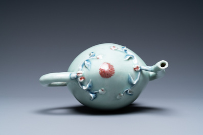 Een Chinese perzikvormige 'cadogan' theepot met reli&euml;fdecor in blauw en koperrood op celadon fond, 19e eeuw