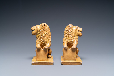 A pair of Flemish or North-French pottery lions, signed and dated 1865