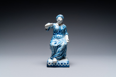 A Dutch Delft blue and white figure of a seated lady, 18th C.