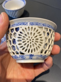 A pair of Chinese blue and white reticulated double-walled cups and saucers, Kangxi