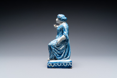 A Dutch Delft blue and white figure of a seated lady, 18th C.