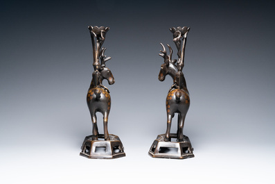 A pair of Chinese bronze deer-shaped candlesticks, Kangxi/Qianlong