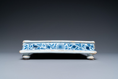 A Dutch Delft blue and white square footed tray on ball feet with chinoiserie design, late 17th C.