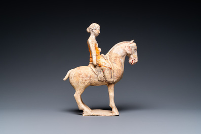 Een Chinese beschilderde aardewerken groep van een dame te paard, Tang