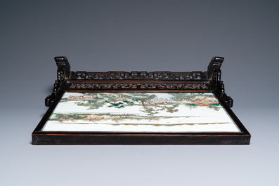 A Chinese rectangular famille rose 'landscape' plaque mounted in a wooden table screen, 19/20th C.