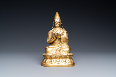 A Sino-Tibetan gilt bronze figure of a lamaic official or dignitary, probably 16th C.