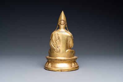 A Sino-Tibetan gilt bronze figure of a lamaic official or dignitary, probably 16th C.