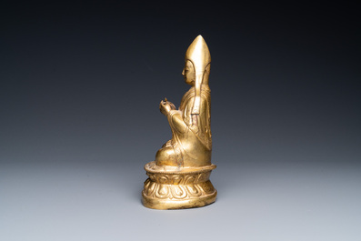Een Sino-Tibetaanse vergulde bronzen figuur van een lama&iuml;sche hoogwaardigheidsbekleder, wellicht 16e eeuw