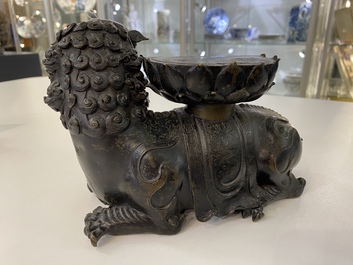 A rare Chinese bronze mythical animal 'Kaiming Shou' holding a lotus base, Ming