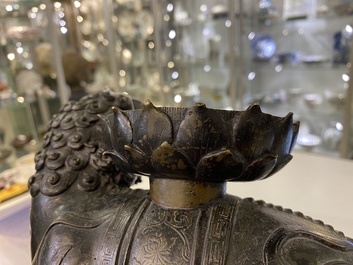 A rare Chinese bronze mythical animal 'Kaiming Shou' holding a lotus base, Ming