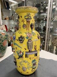 A Chinese yellow-ground famille rose rouleau vase with applied 'antiquities' design, 19th C.