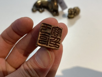 Two Chinese bronze scroll weights and a seal stamp, Qing