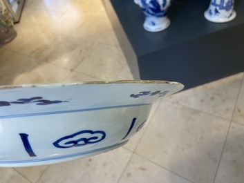 Un plat en porcelaine de Chine en bleu et blanc &agrave; d&eacute;cor de deux femmes et deux lapins dans un jardin, marque et &eacute;poque de Kangxi