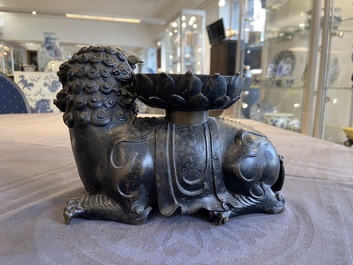 A rare Chinese bronze mythical animal 'Kaiming Shou' holding a lotus base, Ming