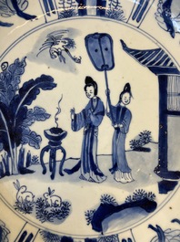 Un plat en porcelaine de Chine en bleu et blanc &agrave; d&eacute;cor de deux femmes et deux lapins dans un jardin, marque et &eacute;poque de Kangxi