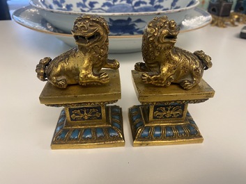 A pair of Chinese gilt bronze Buddhist lions on champlev&eacute; enamel bases, 18/19th C.