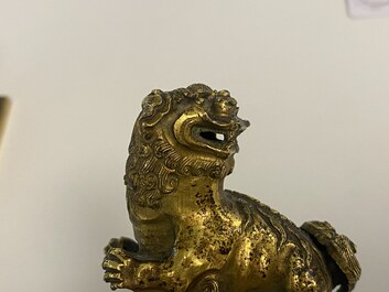 A pair of Chinese gilt bronze Buddhist lions on champlev&eacute; enamel bases, 18/19th C.