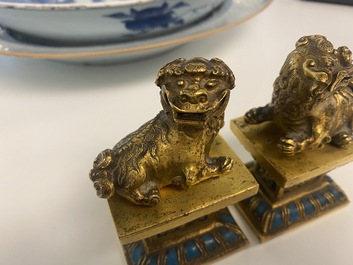 A pair of Chinese gilt bronze Buddhist lions on champlev&eacute; enamel bases, 18/19th C.