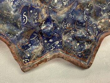 A molded Ilkhanid Lajvardina blue-ground star-shaped tile, Iran, 13/14th C.