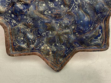 A molded Ilkhanid Lajvardina blue-ground star-shaped tile, Iran, 13/14th C.