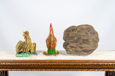Twee polychrome hanen in terracotta en composietsteen en een houten reli&euml;f, 19/20e eeuw