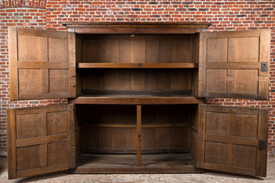 A rare large Flemish oak four-door cupboard with carved X-panels and wrought iron mounts, 1st half 16th C.