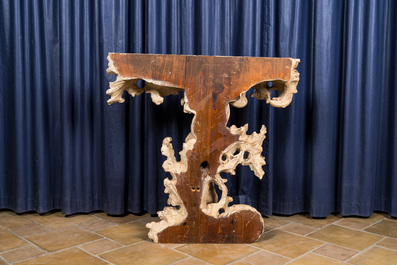 Een Italiaanse gepatineerde houten console met een putto onder gebladerte, 19e eeuw