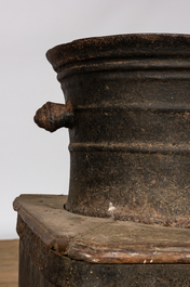 A large iron mortar on wooden stand, 17th C.