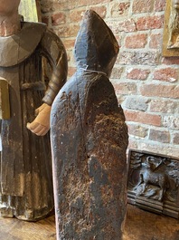 A Flemish carved and polychromed oak figure of a bishop on an armorial base, ca. 1500