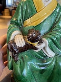 Een Chinese verte biscuit sculptuur van een Luohan met een hond, wellicht Qing