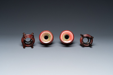 A pair of Chinese peachbloom-glazed vases on wooden stands, Kangxi mark, 19th C.