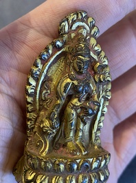 Een vergulde bronzen miniatuur Boeddha met sporen van rode lak, Tibet of Nepal, 15/16 eeuw