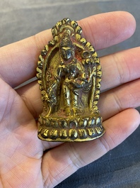 Een vergulde bronzen miniatuur Boeddha met sporen van rode lak, Tibet of Nepal, 15/16 eeuw