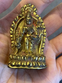 Een vergulde bronzen miniatuur Boeddha met sporen van rode lak, Tibet of Nepal, 15/16 eeuw