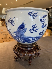 A Chinese blue and white 'dragons and carps' jardini&egrave;re on wooden stand, 19/20th C.