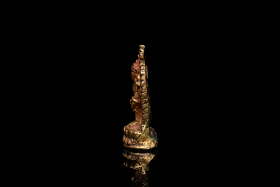 Een vergulde bronzen miniatuur Boeddha met sporen van rode lak, Tibet of Nepal, 15/16 eeuw