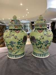 A pair of Chinese famille verte yellow-ground vases and covers, 19th C.