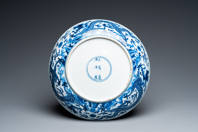 Plat en porcelaine de Chine en bleu et blanc &agrave; d&eacute;cor de dragons, marque et &eacute;poque de Kangxi