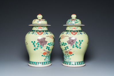 A pair of Chinese famille verte yellow-ground vases and covers, 19th C.