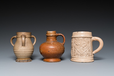 A German stoneware mug and two jugs, Raeren and Cologne, 16/17th C.