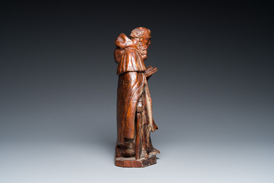 A carved oak group of the reading Saint Anthony with a pig, 17th C.