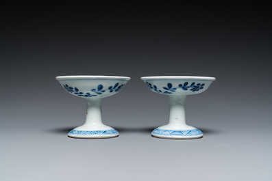 A pair of Chinese blue and white 'lotus scroll' stem cups, Kangxi